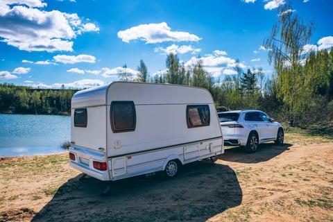 Pre-owned travel trailer parked by lake