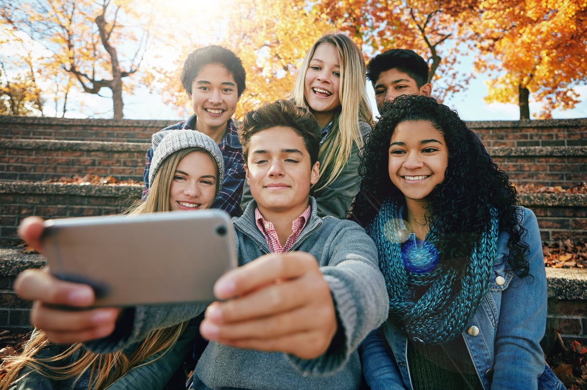 Group of young friends posing for a selfie together outside